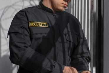 portrait-male-security-guard-with-barbed-wire-fence